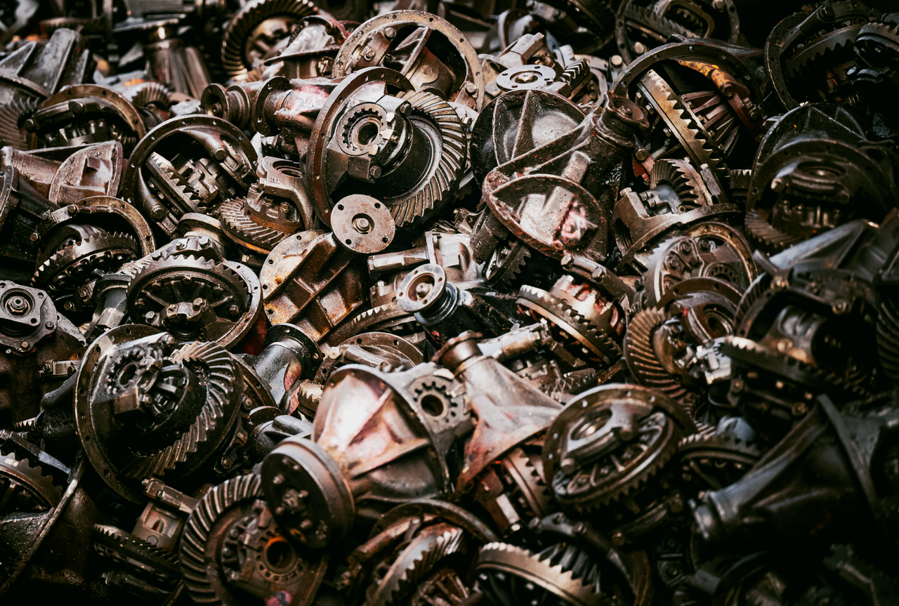 A heap of old mechanical gears in a Bangkok junkyard, showcasing industrial decay.